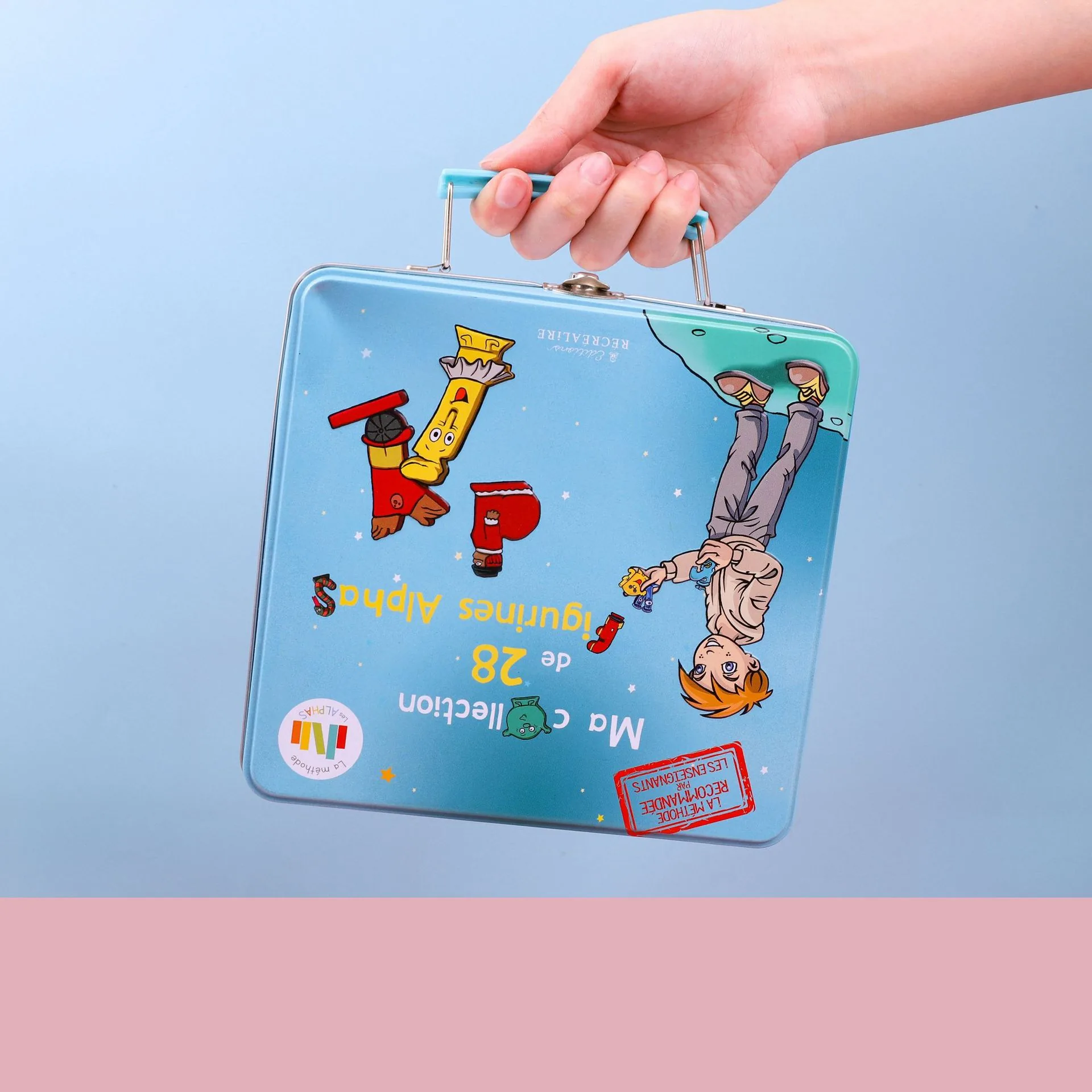 Blue carry tin for the animal alphabet PVC letter toy set held in one hand