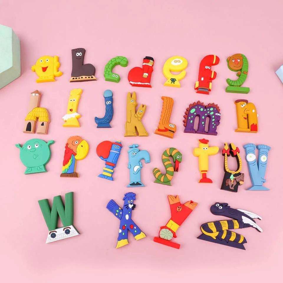 Full animal alphabet PVC letter toy set laid out on a pink background with colorful A to Z character letters
