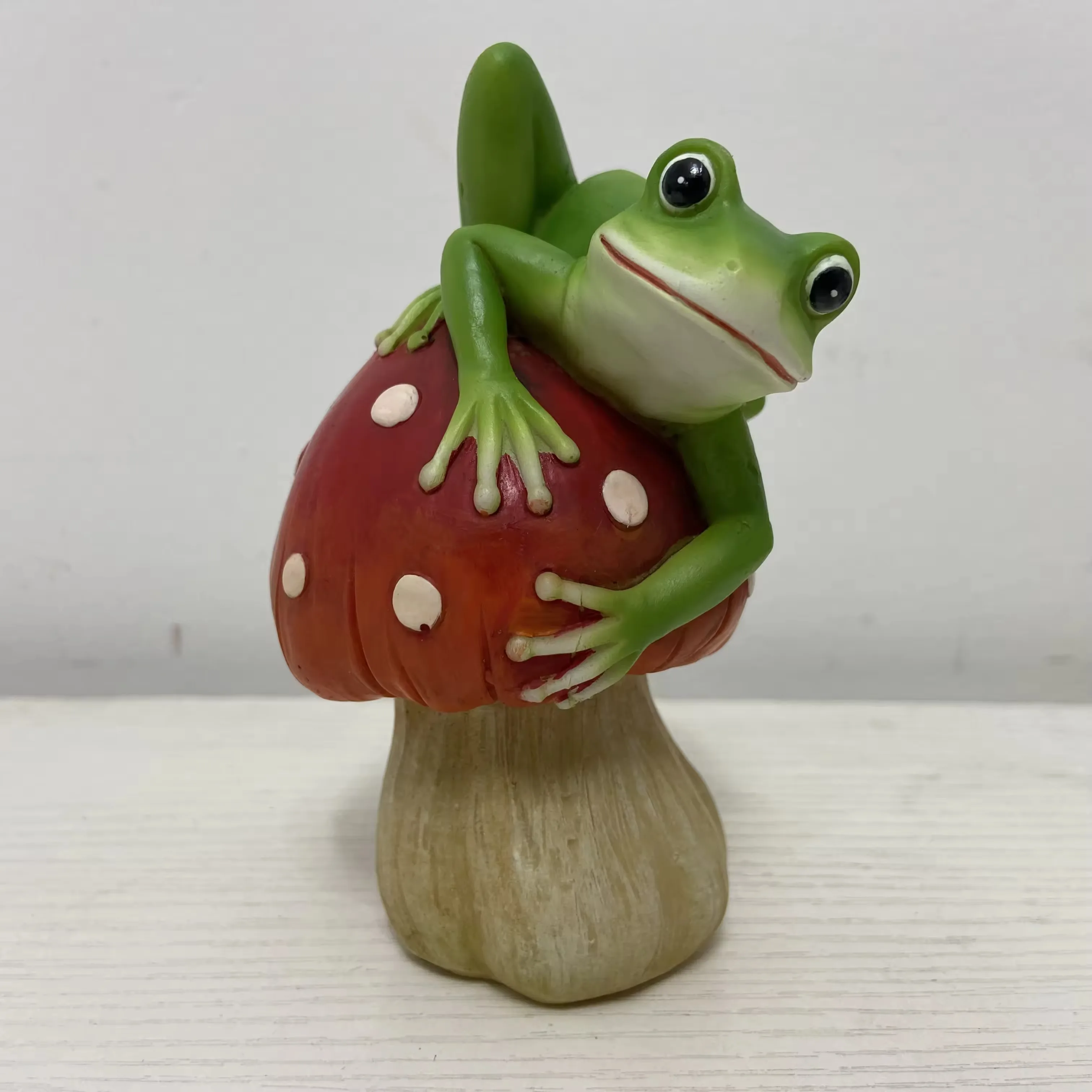 Mini resin frog figurine hugging a red spotted mushroom for tabletop art ornament and business gift use