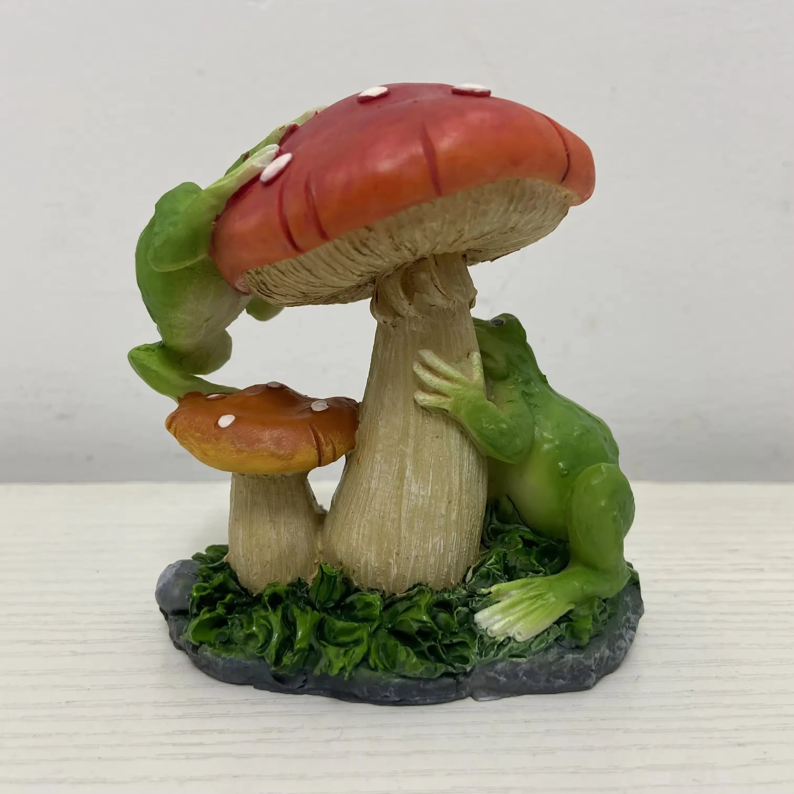 Side view of a resin frog mushroom sculpture with textured mushroom stems and garden base detail