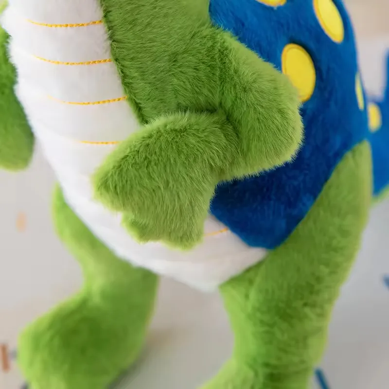 Close-up of the green dinosaur plush arm and blue spotted back panel