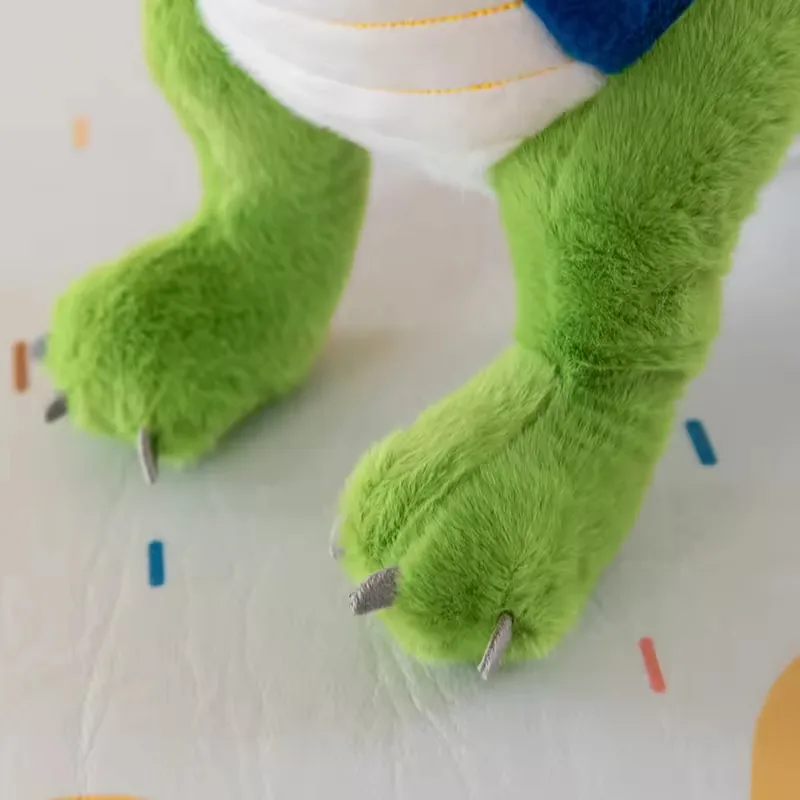 Close-up of dinosaur plush feet with soft green legs and stitched claw tips