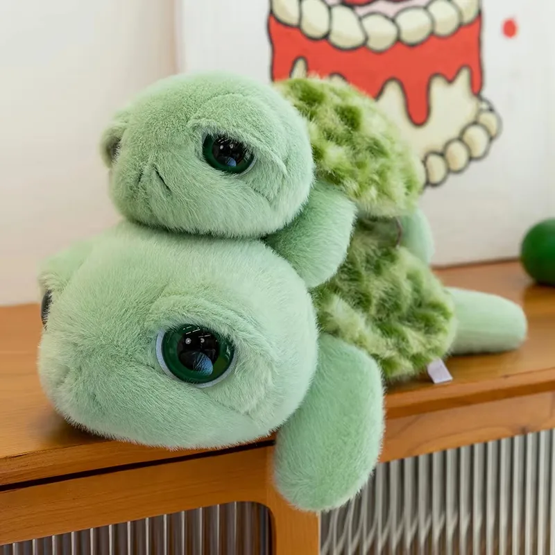Two big eyes turtle plush dolls stacked together to show the rounded face and shell texture