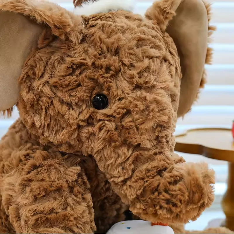Brown birthday elephant plush close-up highlighting curly fur texture and rounded trunk