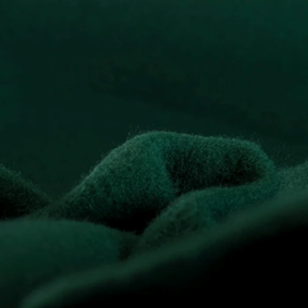 Dark green microfleece fabric surface with a soft matte texture