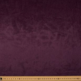 Plum velour fabric swatch with ruler showing even sheen and stable color presentation under light