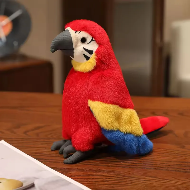 Scarlet plush parrot toy with yellow and blue wings posed upright on a tabletop