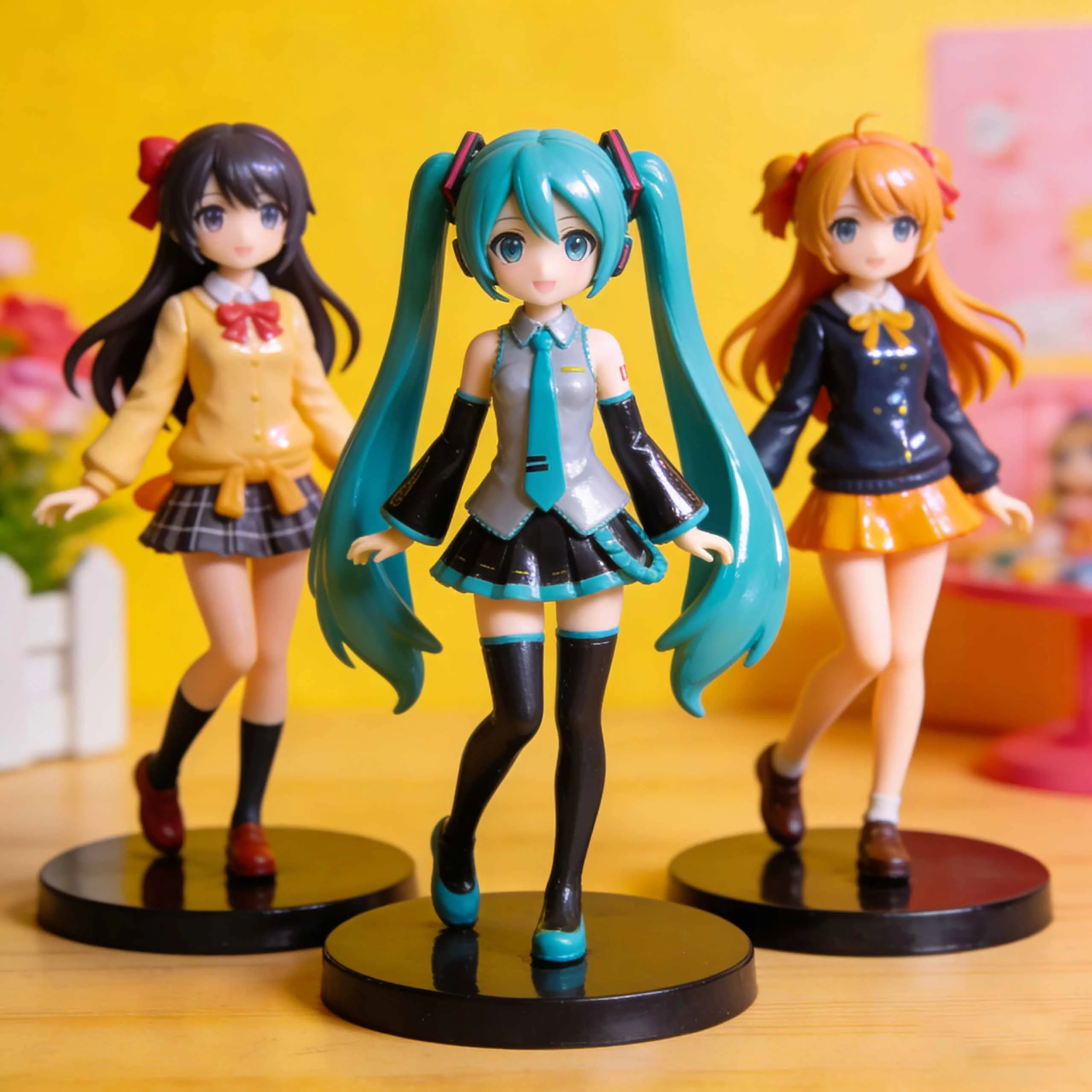 Anime-style PVC character trio with teal twin-tail lead and two school-uniform companions