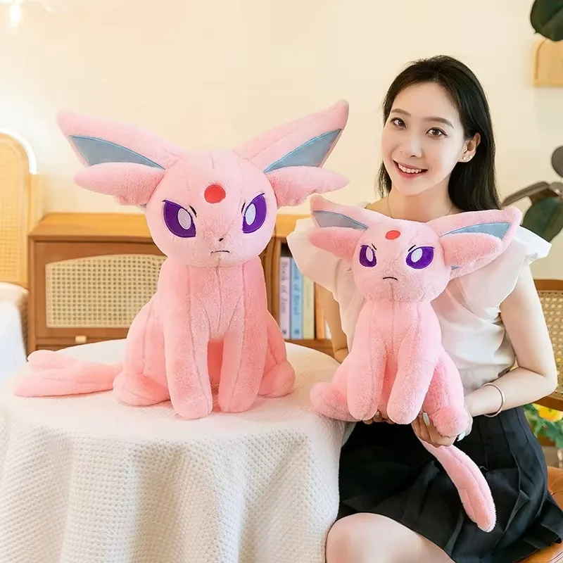 Model holding two Espeon plush dolls in different sizes for character gift and display programs