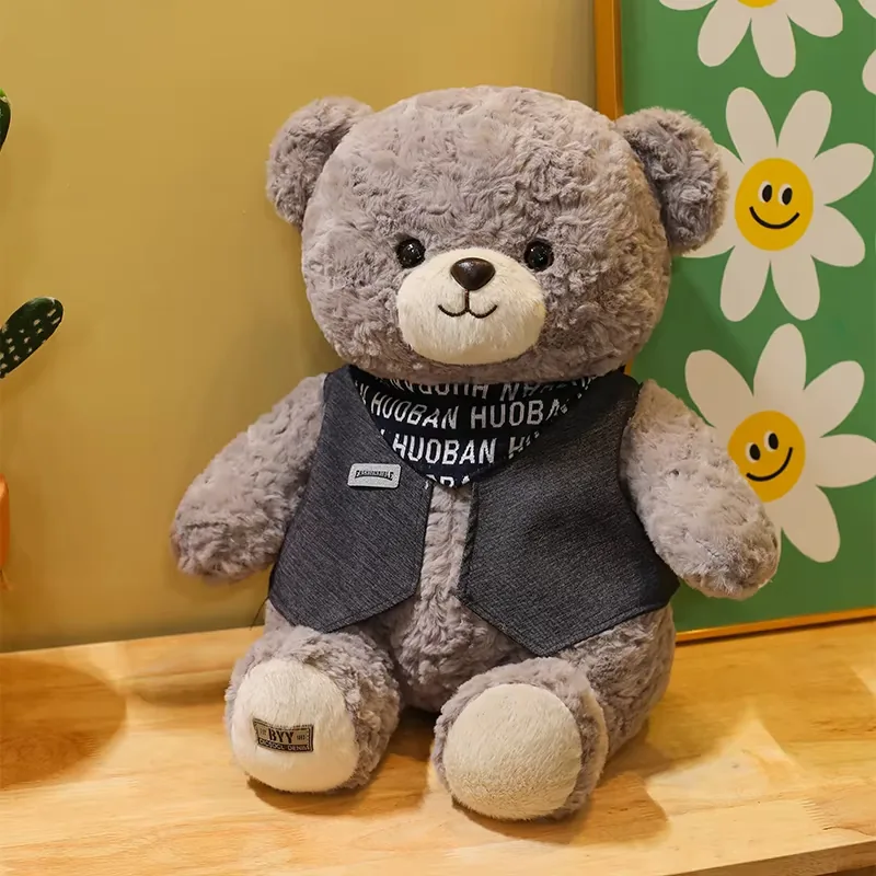 Grey teddy bear plush doll shown in a warm lifestyle setting with floral art and display-friendly seated posture