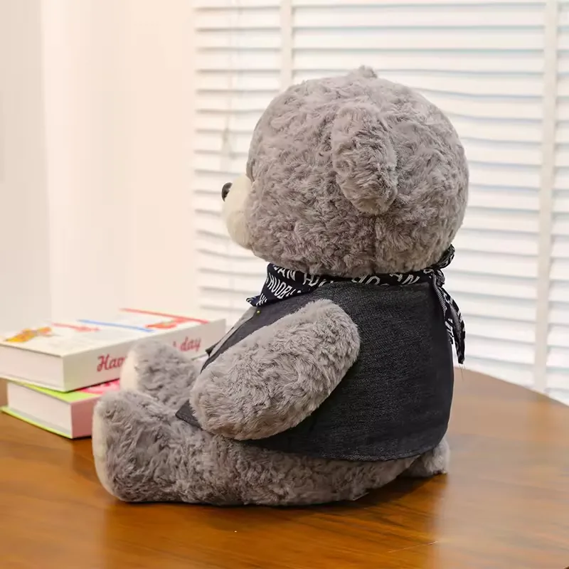 Side view of grey teddy bear plush doll seated with visible vest coverage and rounded body volume