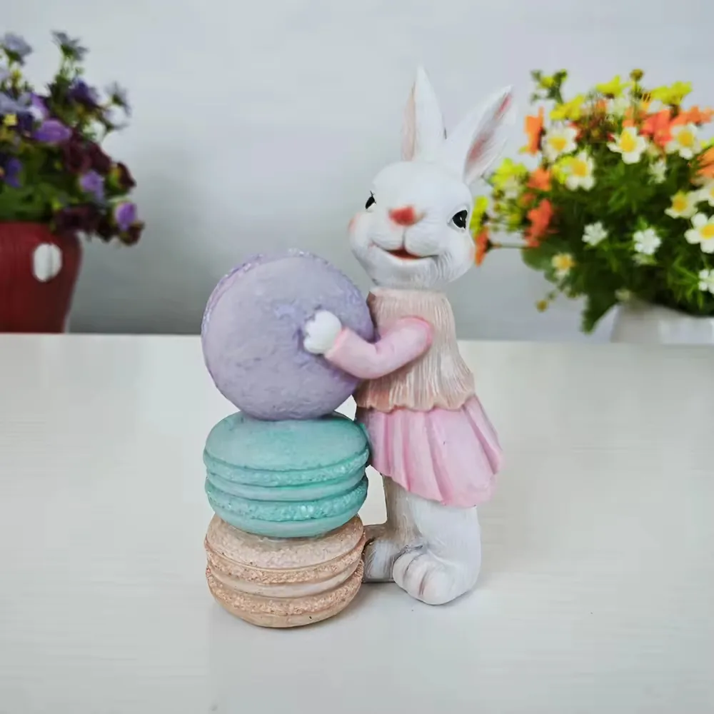 Hand-painted resin rabbit figurine posed beside oversized pastel macarons for boutique spring decor and gift displays