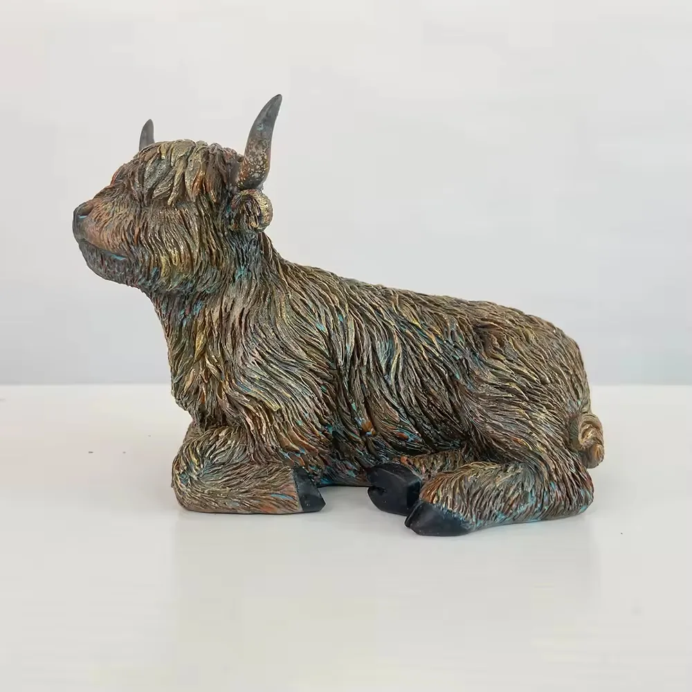 Left-side view of a reclining resin Highland cow figurine for tabletop and countryside decor programs