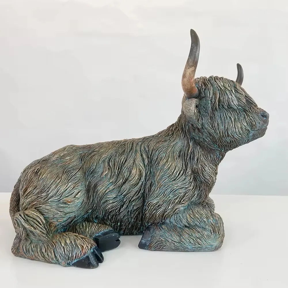 Reclining resin Highland cow figurine with layered fur texture and raised horns viewed from the right side