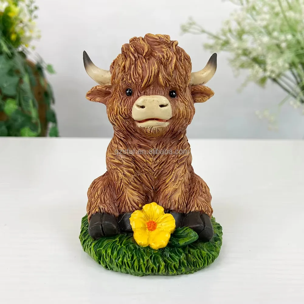 Front view of a resin Highland cow calf figurine seated on a grassy base with a yellow flower accent