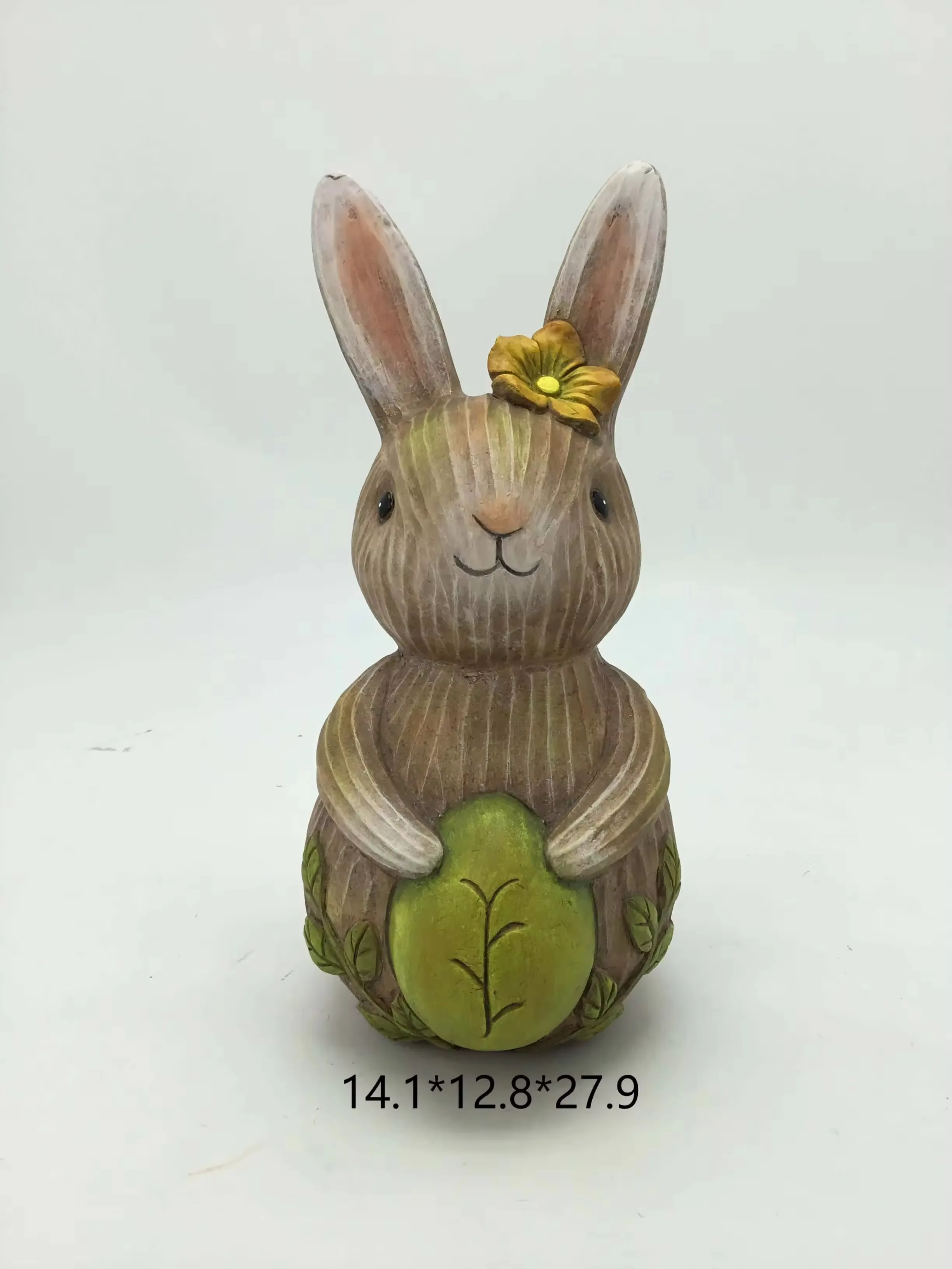 Spring resin rabbit figurine holding a green Easter egg with a flower accent on one ear
