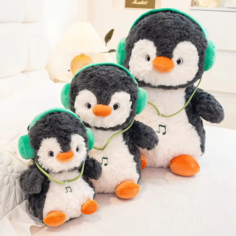 Three headphones penguin plush dolls arranged on a bed to show the full size ladder from small to large