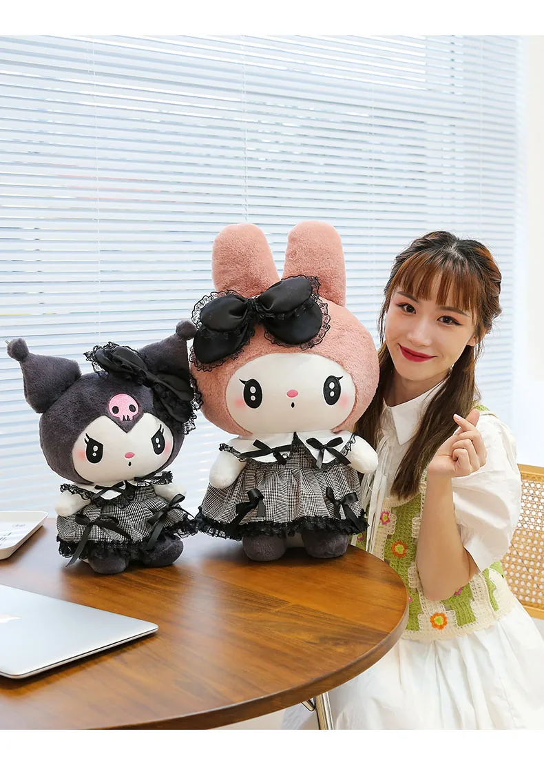 My Melody and Kuromi gothic plush dolls displayed on a desk beside a seated model