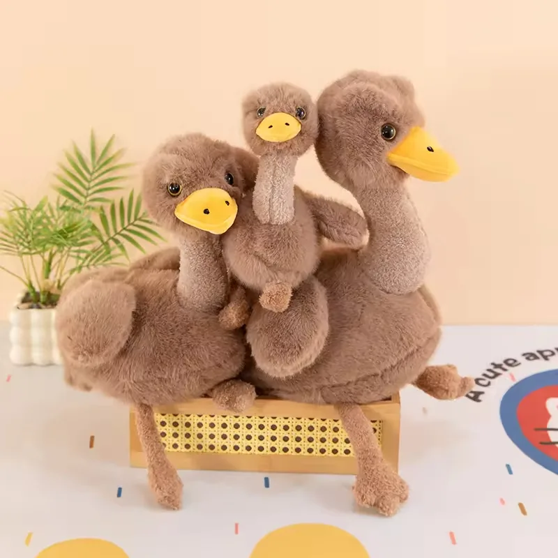 Large, medium, and small ostrich plush dolls grouped together on a bench display