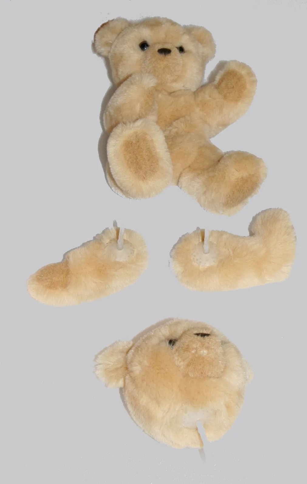 Teddy bear body assembled from separate plush components with limbs pinned in place