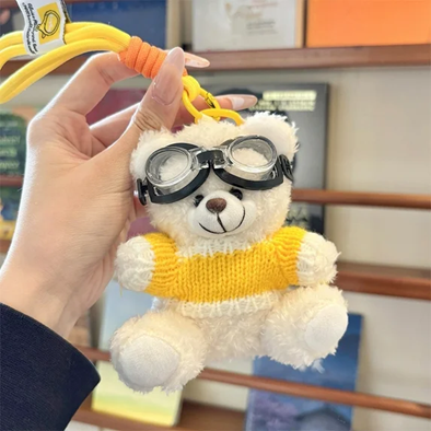 Small teddy bear plush keychain with a hanging loop and attached accessories