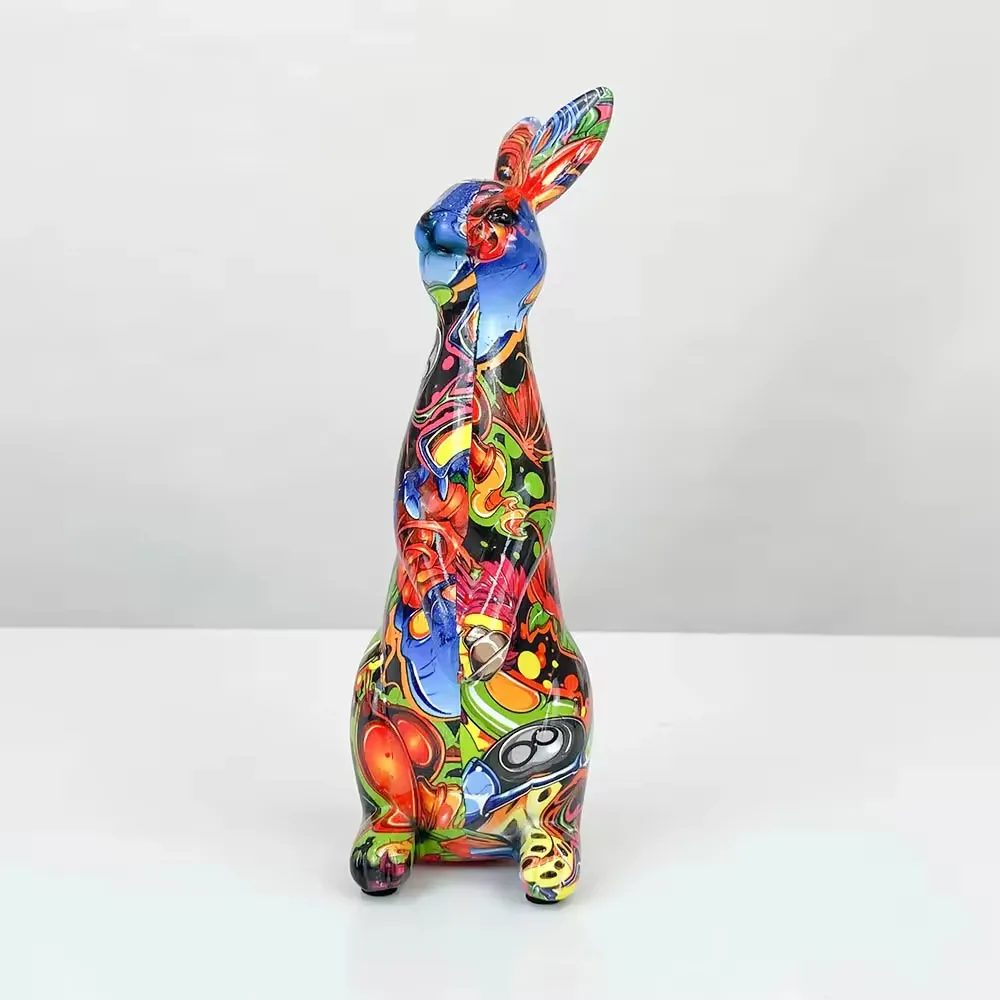 Front view of a glossy pop-art resin rabbit statue with vivid blue, red, green, and black abstract graphics