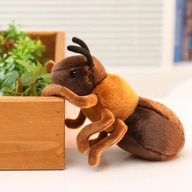 Side view of a realistic ant plush toy climbing beside a wooden planter box