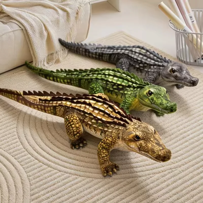 Gray, green, and tan realistic crocodile plush dolls arranged on a rug beside a sofa for gift and home-display styling