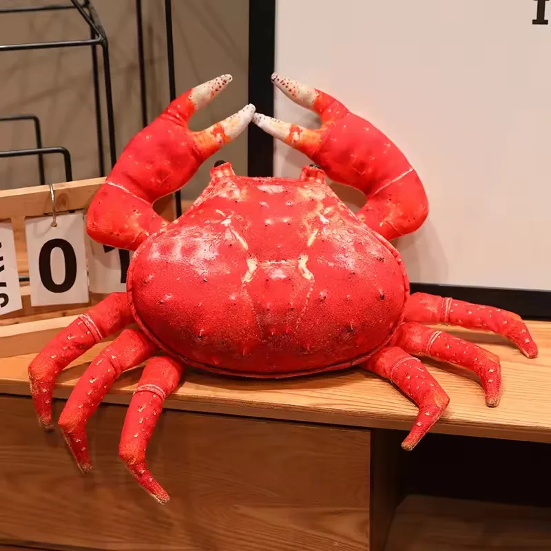 Rear view of red plush crab toy with rounded shell shape, raised claws, and multiple side legs