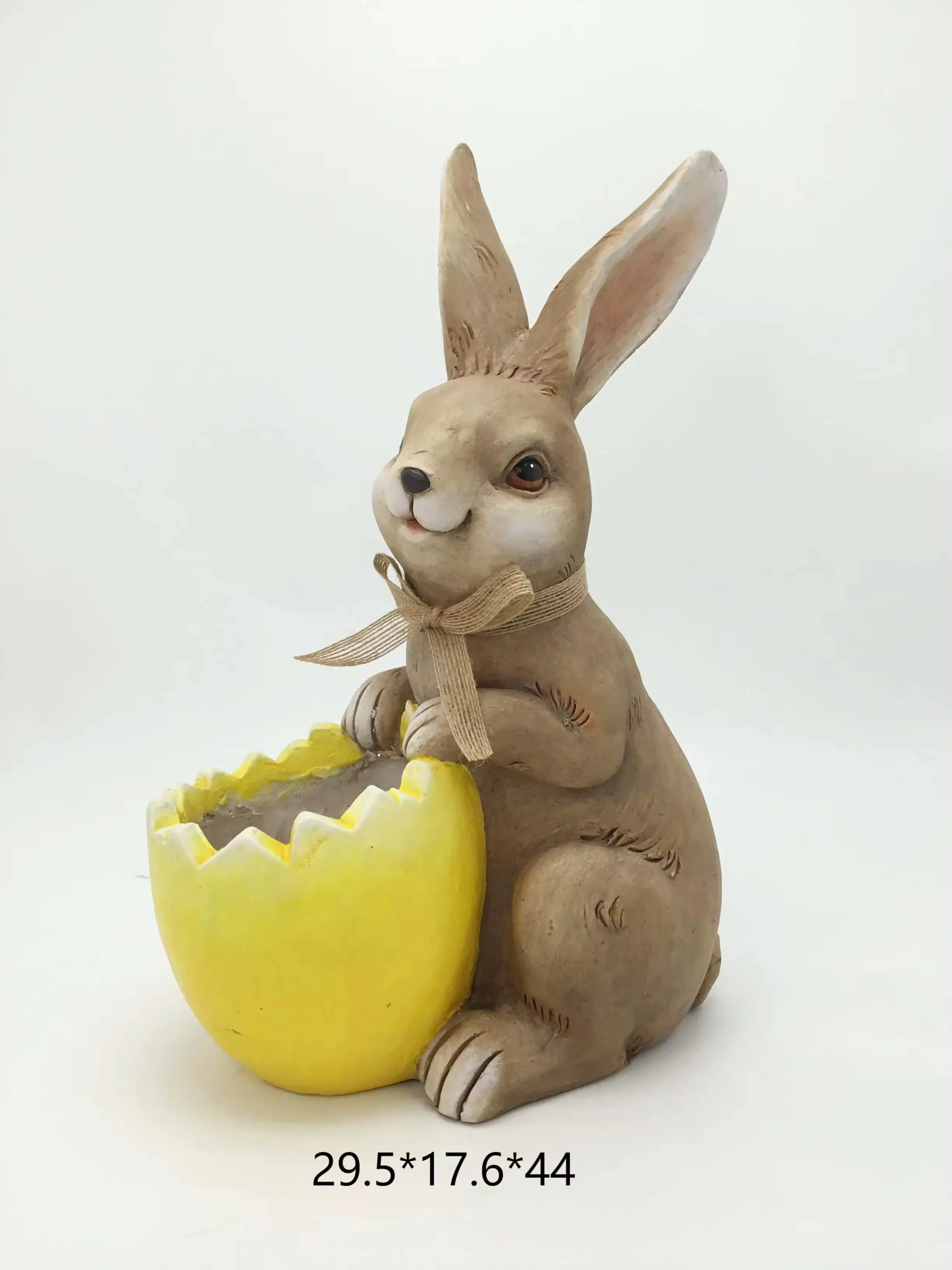 Realistic resin rabbit figurine seated beside a yellow cracked eggshell planter for Easter retail display