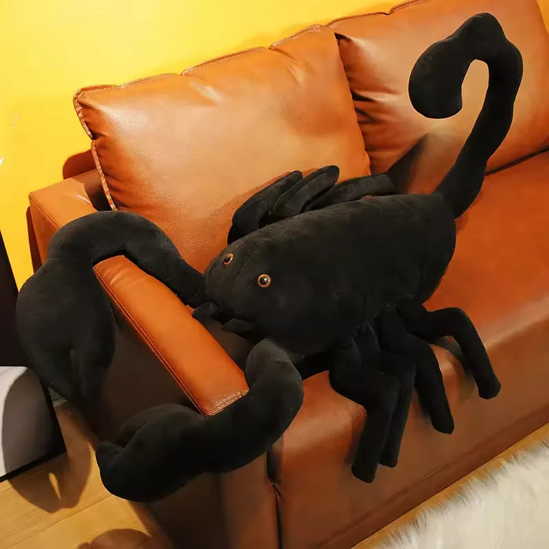 Three-quarter lifestyle angle of realistic scorpion plush doll draped across a sofa arm