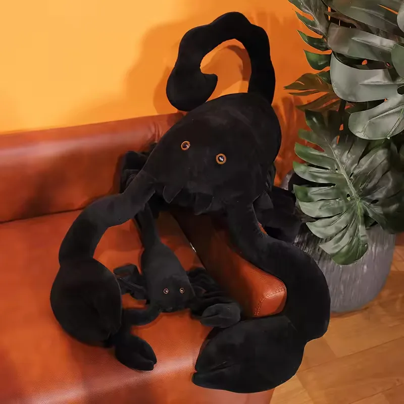 Large black scorpion plush doll displayed with a smaller matching scorpion plush companion on a sofa