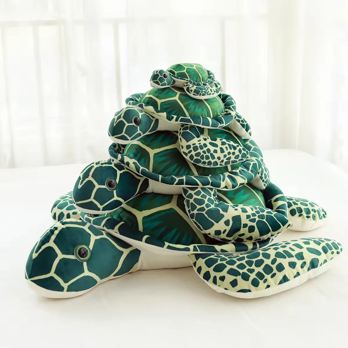 Stacked realistic sea turtle plush pillows in multiple sizes with green shell prints and flat marine-animal bodies