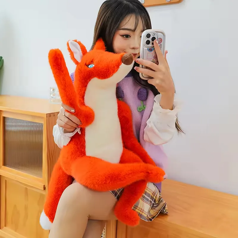 A person holding a large red fox plush doll from the front to show body height and long-leg scale