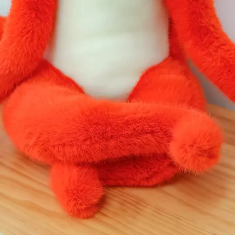 Close-up of the red fox plush doll's crossed fuzzy legs and white belly panel in a seated pose