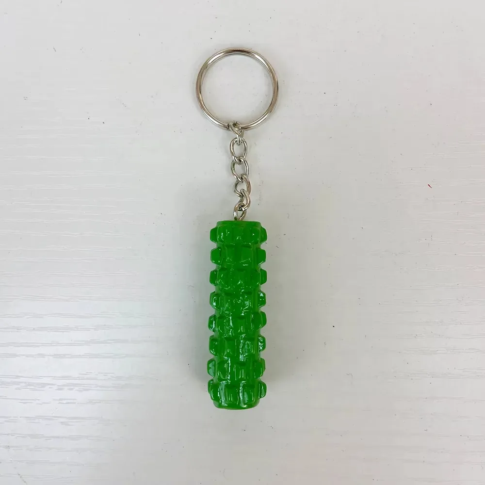 Front view of a green foam roller resin keychain with textured body and metal ring