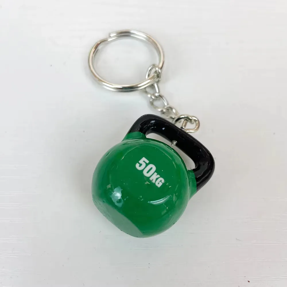 Green kettlebell resin fitness keychain with 50KG marking and black handle shown at an angle