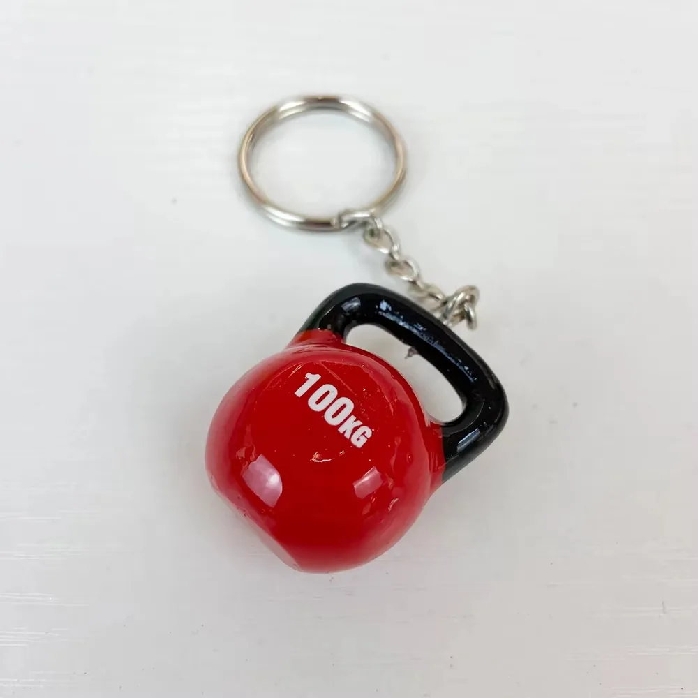 Red kettlebell resin fitness keychain with 100KG marking and black handle shown at an angle