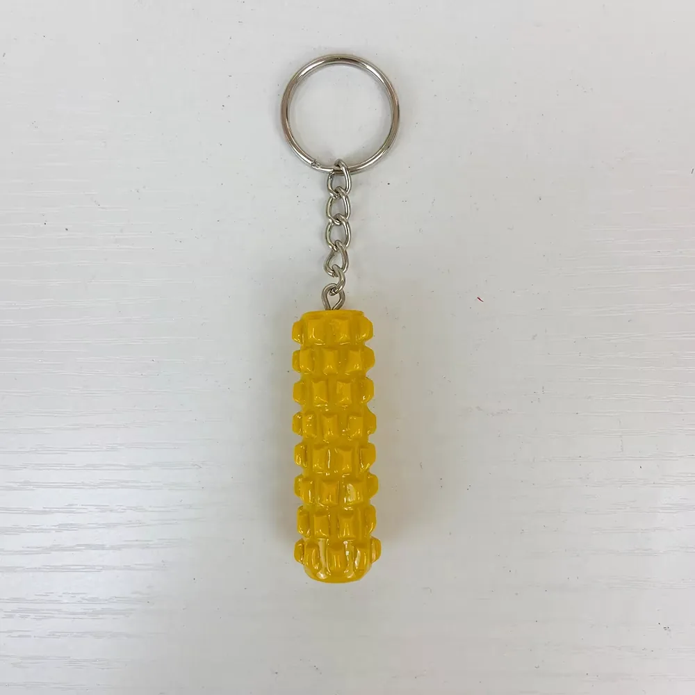 Front view of a yellow foam roller resin keychain with textured massage grid pattern
