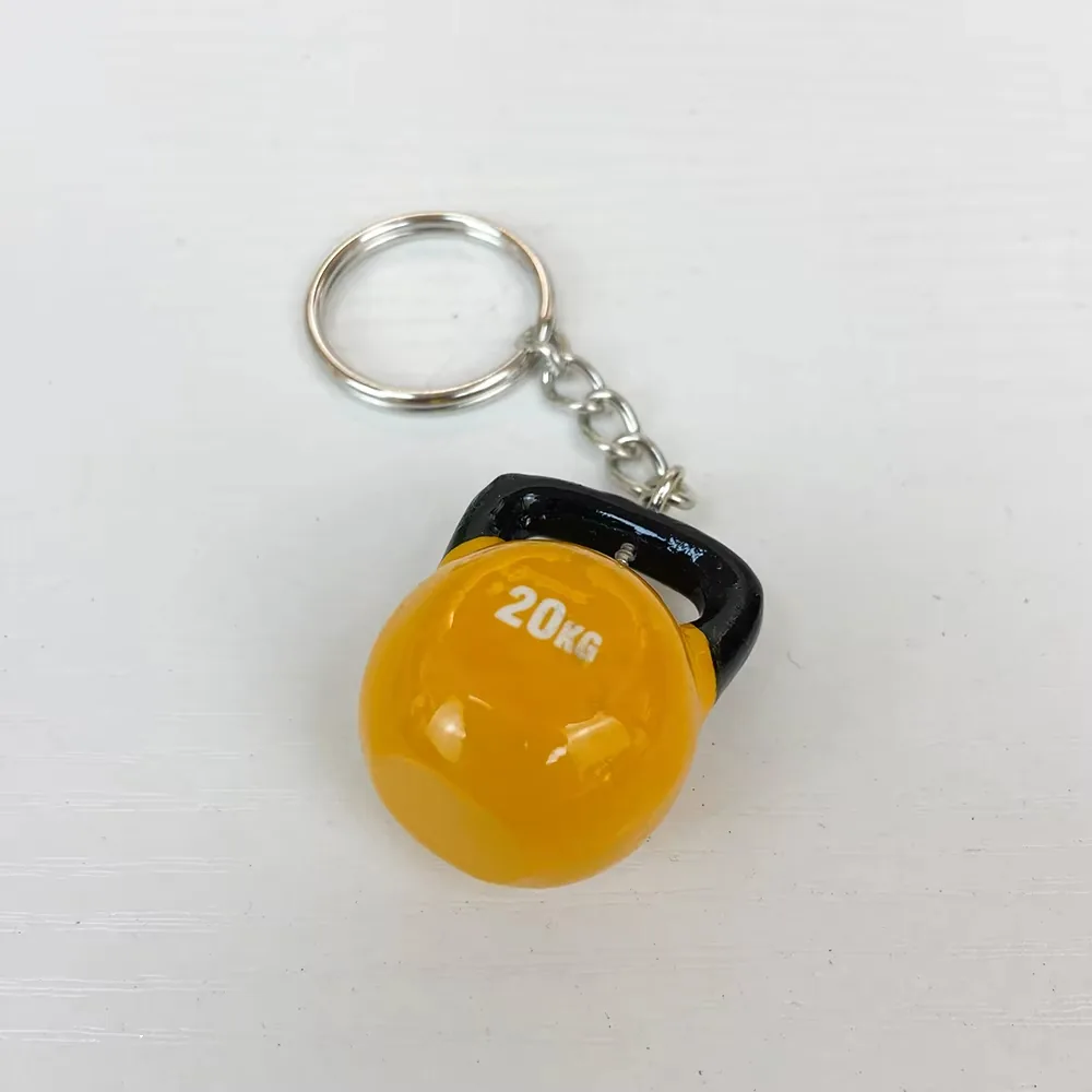 Yellow kettlebell resin fitness keychain with 20KG marking and black handle shown at an angle