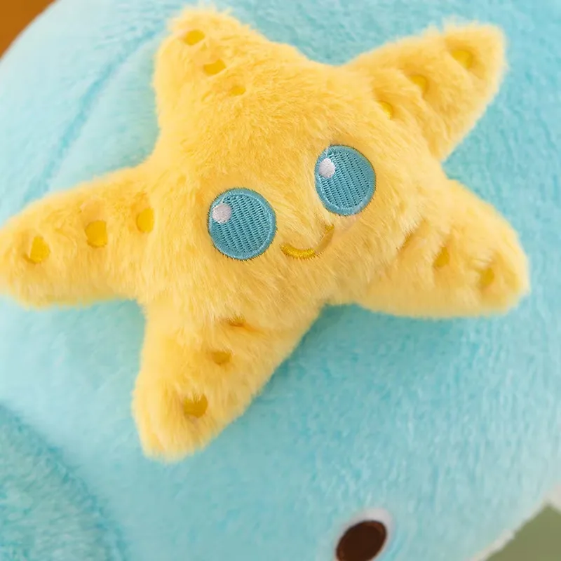 Smiling yellow starfish applique attached to the top of the blue dolphin plush pillow
