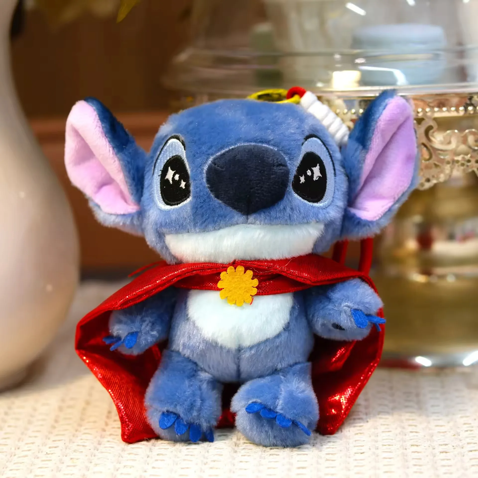 Stitch keychain plush with a glossy red cape and flower clasp