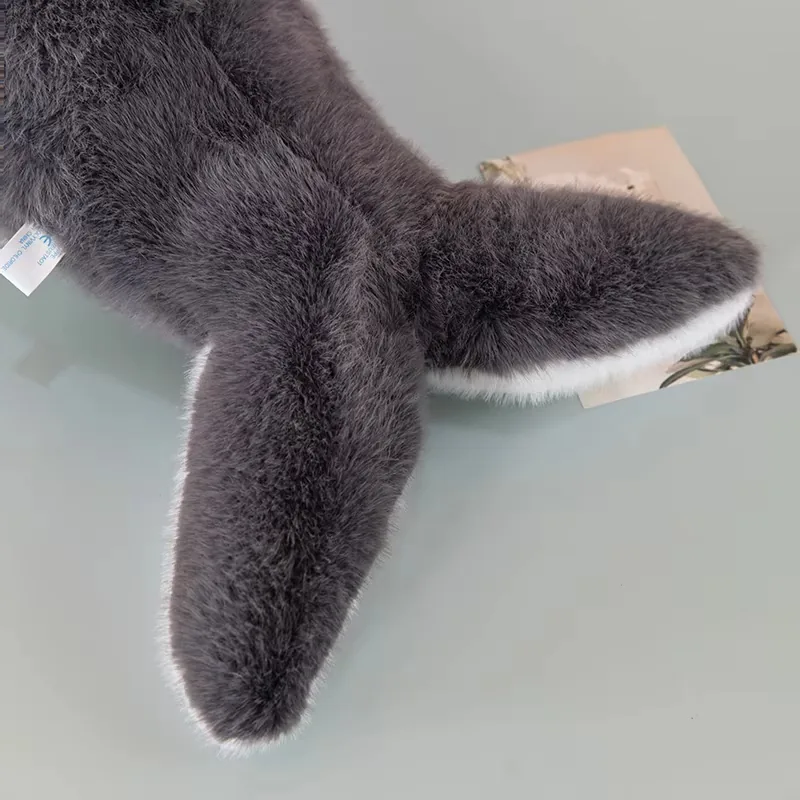 Close-up of the whale plush pillow tail and rear body showing soft grey fur and white trim
