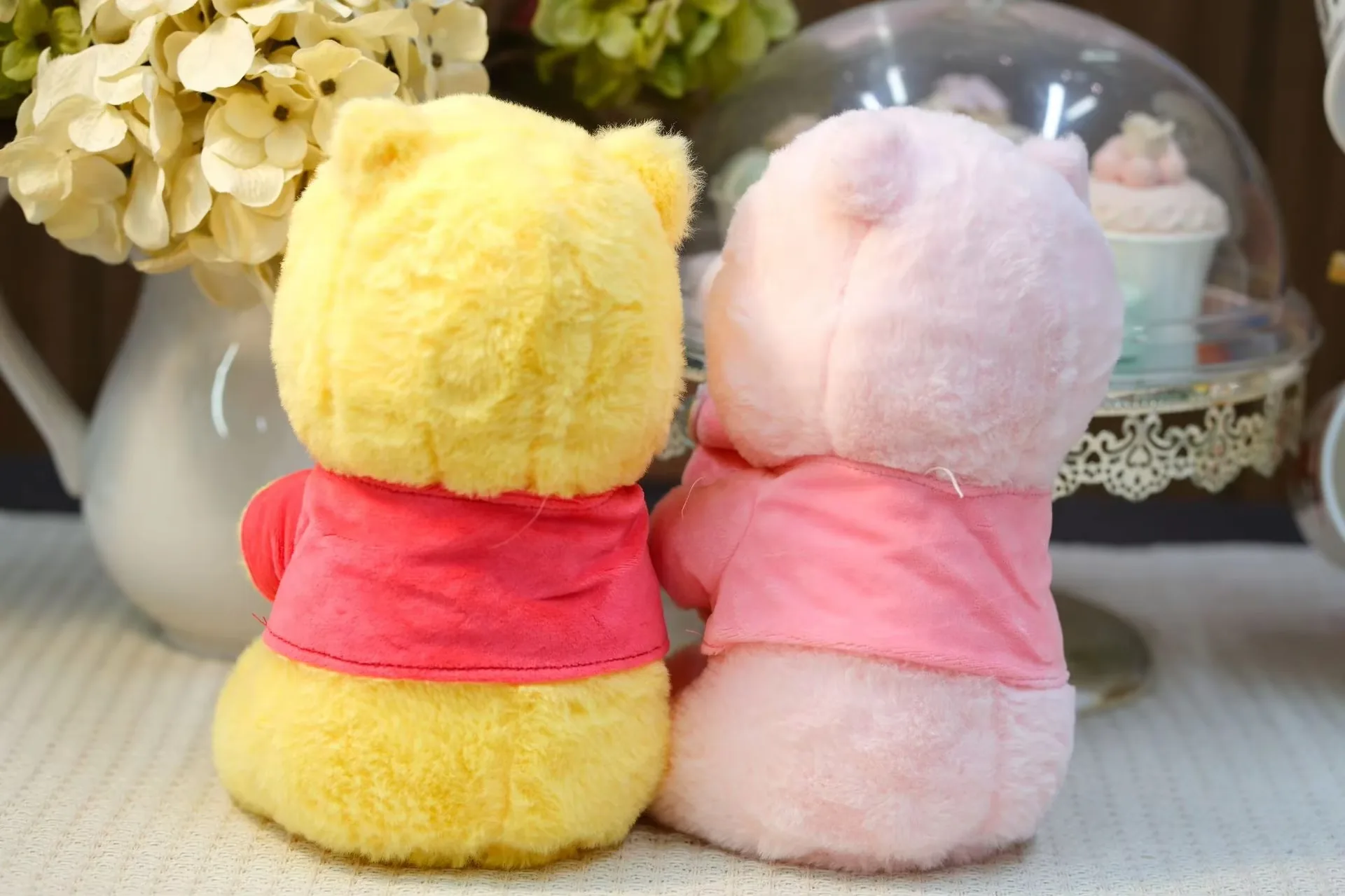 Back view of yellow and pink honey jar bear plush dolls showing shirt coverage and rounded plush backs