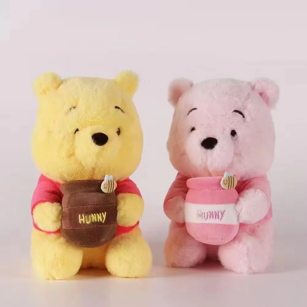 Front view of the yellow and pink honey jar bear plush dolls displayed side by side